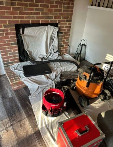 Woodbridge, VA: Interior living room with fireplace renovation gear, tools, orange pressure washer, red toolbox, fabric-covered seating.