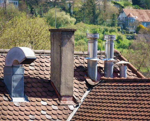 An image of a roof with different chimneys