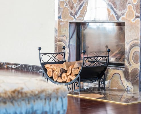 A stack of wood in front of a proper fireplace and chimney serviced by a chimney professional