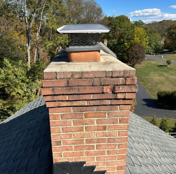 chimney repairs woodbridge va Brick chimney on sloped roof, autumn trees, Woodbridge, VA; suggests chimney repair needs