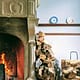 Firewood stacked against a wall in a home that is properly preserving the life of their fireplace that is also burning well