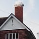 A smoking chimney on top of a residential house in northern virginia that would need chimney cleaning in different seasons.